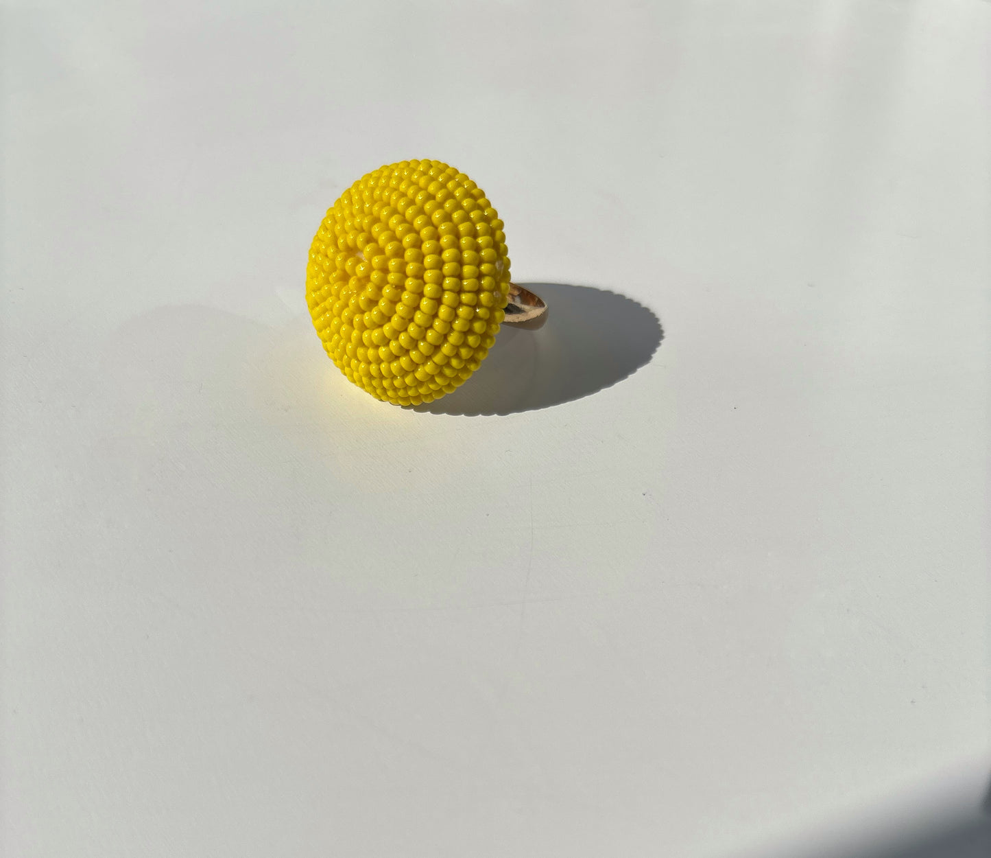 Bague jaune en perles, accessoire élégant pour un style raffiné et intemporel.