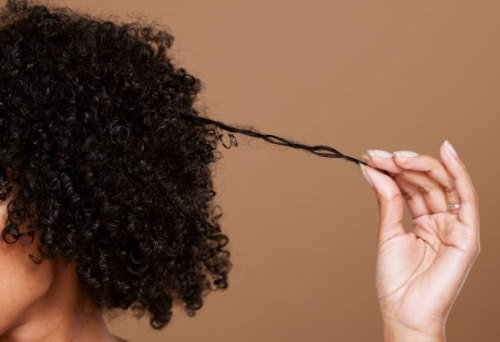 femme aux cheveux afros en bonne santé sur fond marron
