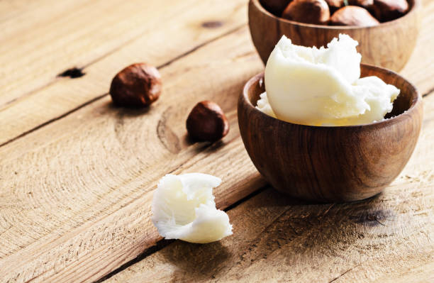 beurre de karité dans un pot en bois sur une table en bois 