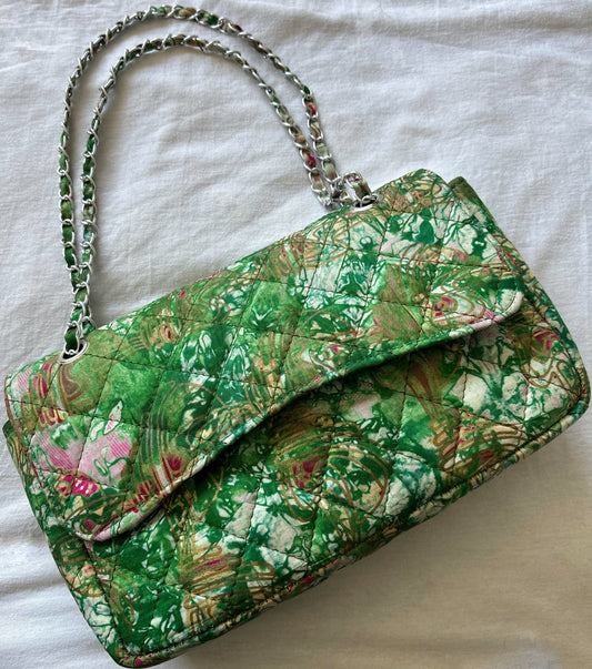 Sac bandoulière matelassé en tissu imprimé africain, motifs verts et roses avec bandoulière en chaîne, élégant et original.